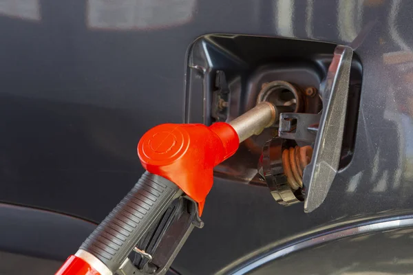 Fill the car with fuel. The car is filled with gasoline at a gas station. Gas station pump. Man refueling gasoline with fuel in a car, holding a nozzle. Limited depth of field. Blurred image — Stock Photo, Image