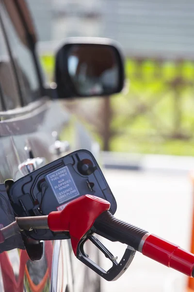 Llena el auto con combustible. El coche está lleno de gasolina en una gasolinera. Bomba de gasolinera. Hombre repostando gasolina con combustible en un coche, sosteniendo una boquilla. Profundidad de campo limitada. Imagen borrosa — Foto de Stock