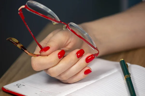 Lüks kısa manikür Kırmızı çivi tasarımı. kadın el tutma gözlükleri Alan sınırlı derinlik — Stok fotoğraf