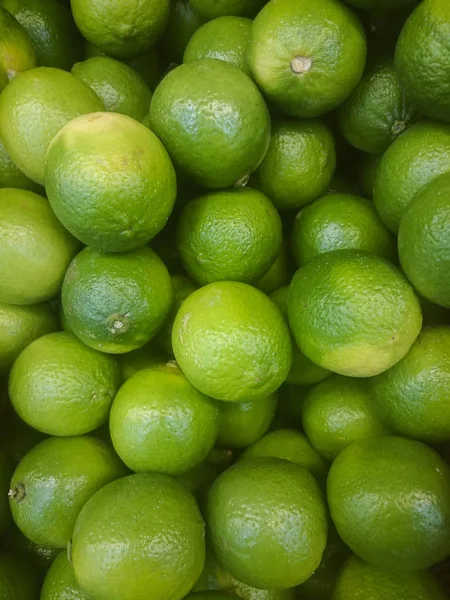Background of fresh green limes close seup, fruits on sale, mobile photo — стоковое фото