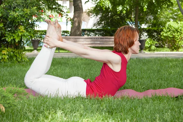 Sabah parkında yoga yapan genç bir kadın. — Stok fotoğraf