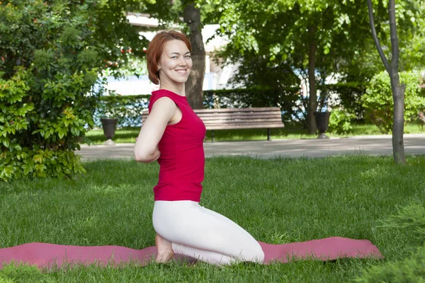 Sabah parkında yoga yapan genç bir kadın. — Stok fotoğraf