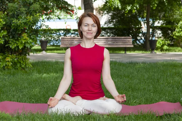 Frau auf einer Yogamatte zum Entspannen im Freien. — Stockfoto