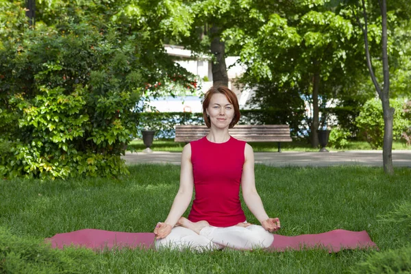 Frau auf einer Yogamatte zum Entspannen im Freien. — Stockfoto