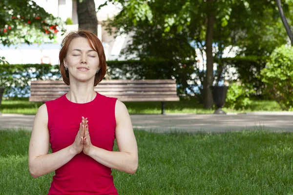 Beautiful young woman sitting in Lotus position — Stock Photo, Image