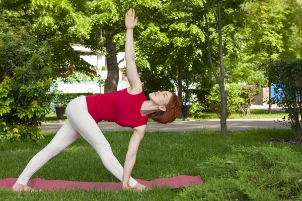 Молода жінка робить йогу в ранковому парку — стокове фото