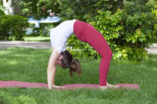 Junge Frau macht Yoga im Morgenpark — Stockfoto