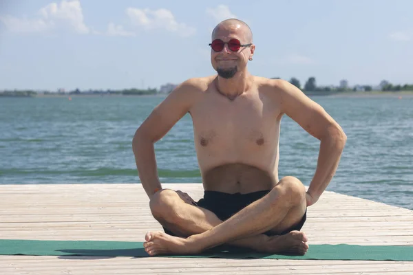 Young man doing yoga exercise in the lotus position — ストック写真