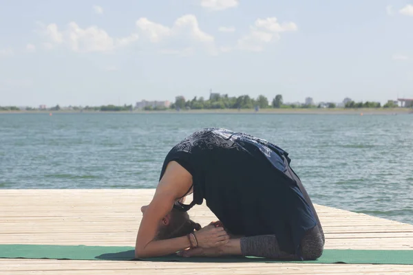 Beautiful woman practicing Yoga by the lake — Stock Photo, Image