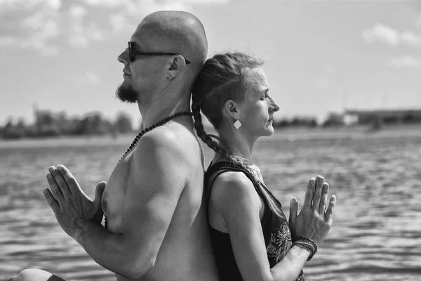 Homem e mulher grávida estão fazendo ioga na praia — Fotografia de Stock