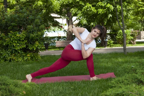 Lächelndes Mädchen im Park Übung auf der Yogamatte, hoher Ausfallschritt — Stockfoto
