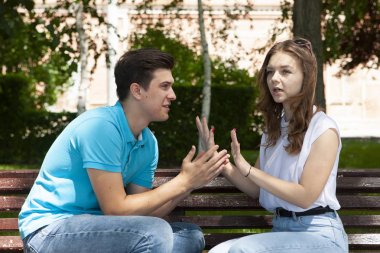 Parktaki ahşap bankta otururken birbirleriyle konuşmayan çelişkili çiftler.