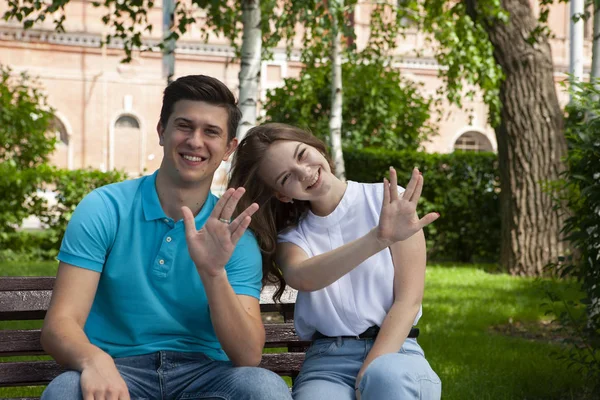 Krásný mladý pár sedí na lavičce v parku — Stock fotografie