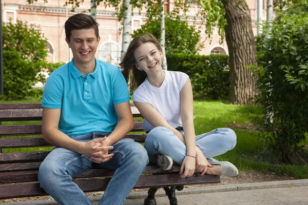 美丽的年轻夫妇坐在公园的长椅上 — 图库照片