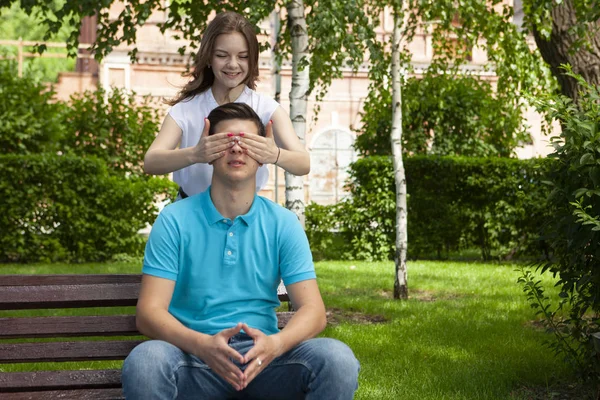 Beautiful young couple sitting on a bench in the park — Stock Photo, Image