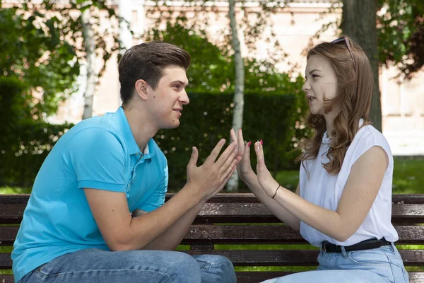 Conflicted couple not talking to each other seated on a wooden bench in park