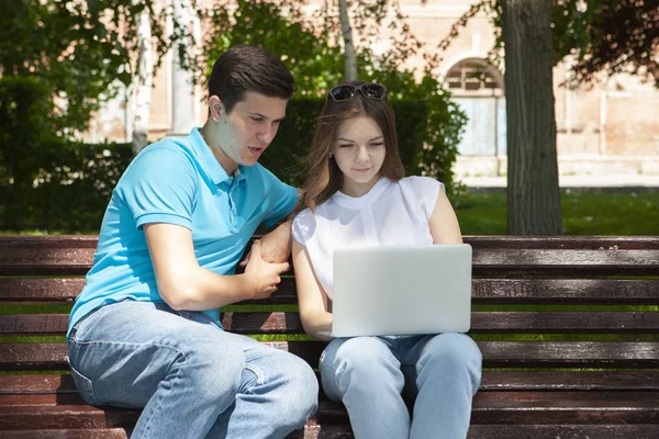 Joven pareja guapa usando cuaderno en el parque público —  Fotos de Stock