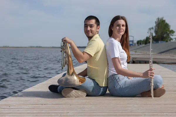 吹喇叭的家伙和在湖上吹长笛的女孩 — 图库照片
