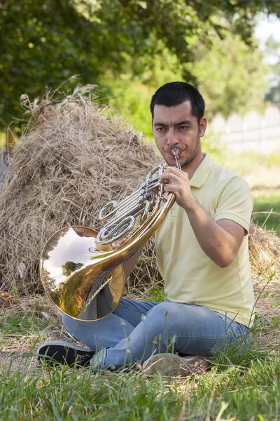 French horn player playing music instrument Man hornist classical musician