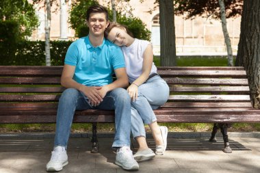 Parktaki bankta oturan genç ve güzel bir çift