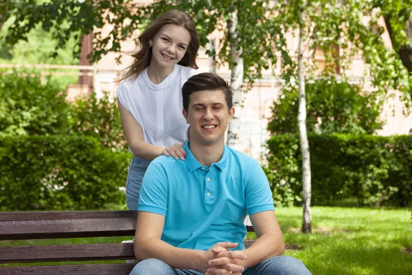 Krásný mladý pár sedí na lavičce v parku — Stock fotografie