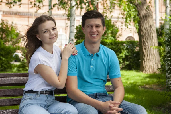 Mooi jong paar zitten op een bank in het park — Stockfoto