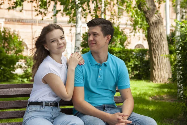 Красива молода пара сидить на лавці в парку — стокове фото