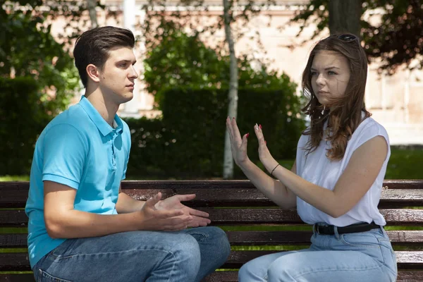 Conflicted couple not talking to each other seated on a wooden bench in park — Stock Photo, Image