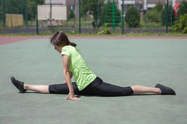 Spor figürlü genç fitness kızı esneme hareketleri yapıyor. — Stok fotoğraf