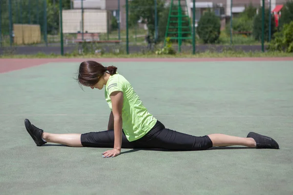 Spor figürlü genç fitness kızı esneme hareketleri yapıyor. — Stok fotoğraf
