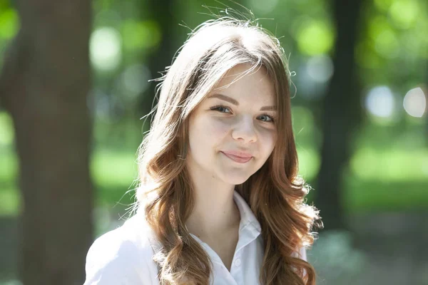 Hermosa chica con el pelo corto y rubio camina en el parque. Linda chica se ve feliz y sonríe . — Foto de Stock