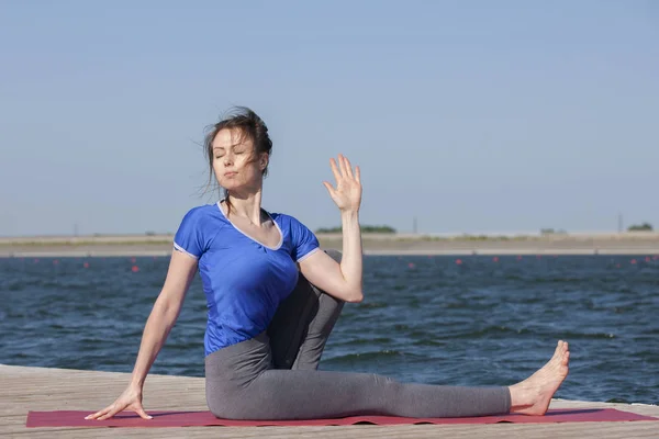 Donna che fa esercizio yoga in un lago — Foto Stock