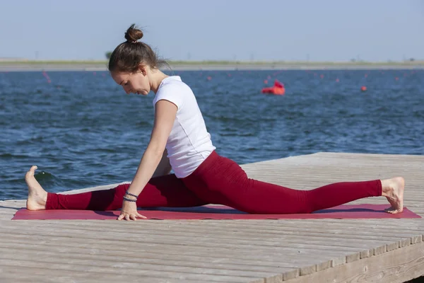 Genç kız uygulamaları yoga göle zevk gizlilik ve konsantrasyon, güneş ışığı kavramı kıyısında