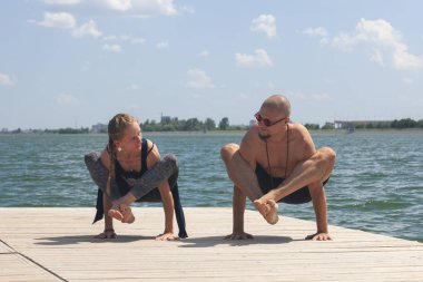 Atletik güçlü çift zor yoga pratik açık havada poz