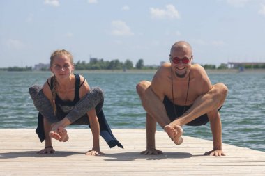 Atletik güçlü çift zor yoga pratik açık havada poz