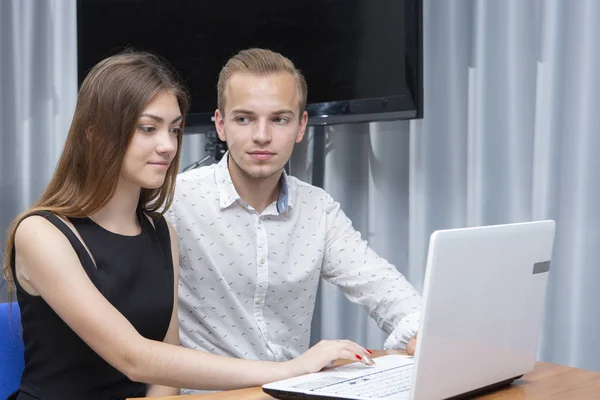 Gruppe von zwei jungen, euphorischen Studenten, die sich Prüfungsergebnisse in einem Laptop in einer Tabelle ansehen — Stockfoto