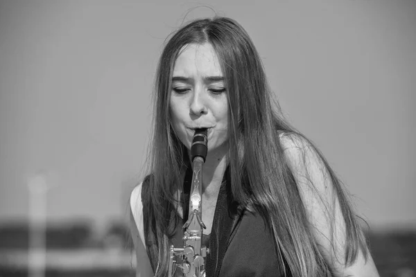Schöne Brünette spielt Saxofon im Park — Stockfoto