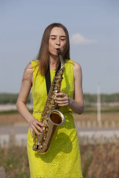 Young beautiful saxophonist with saxophone - outdoor in nature — Stock Photo, Image