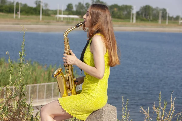 Jovem saxofonista bonito com saxofone - ao ar livre na natureza — Fotografia de Stock