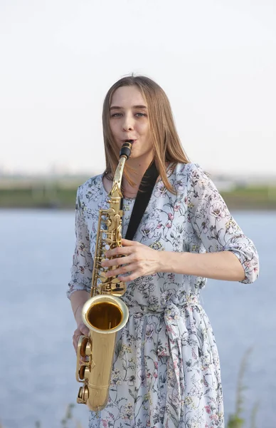 Young woman with saxophone in the park — 스톡 사진