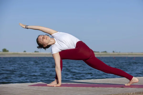 Pilates yoga esercizio di allenamento all'aperto nel molo del lago — Foto Stock