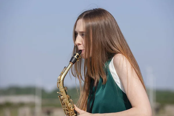 Jovem saxofonista bonito com saxofone - ao ar livre na natureza — Fotografia de Stock