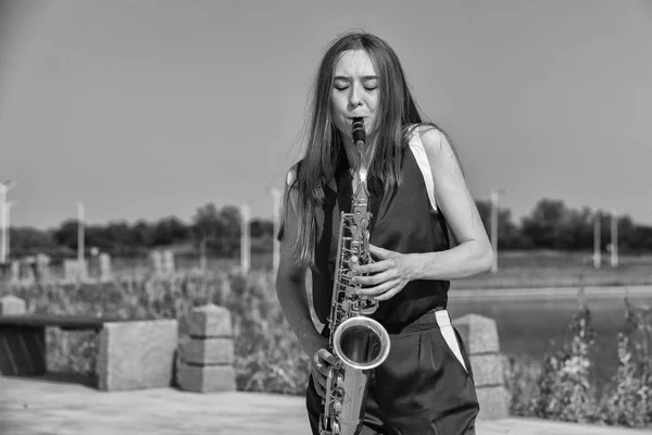 Young beautiful saxophonist with saxophone - outdoor in nature — Stock Photo, Image