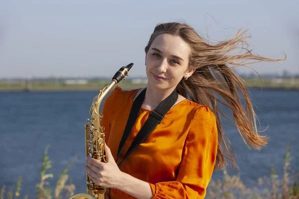 Jovem mulher com saxofone com fundo natureza — Fotografia de Stock
