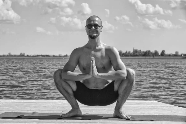 Profile shot of mature man meditating in lotus position on pier against lake — Stock Photo, Image