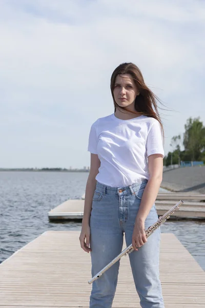 Mooie vrouw spelen fluit in Waterfront Glimlachende vrouw. — Stockfoto