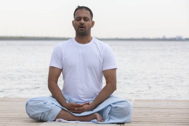 Sabah yoga egzersizi yapan adam.