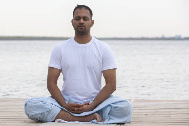 Sabah yoga egzersizi yapan adam.