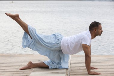 Olgun adam göl karşı iskelede lotus pozisyonda meditasyon profil resmini