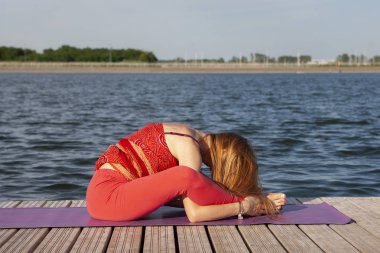 Yoga yapan genç bir kadın..